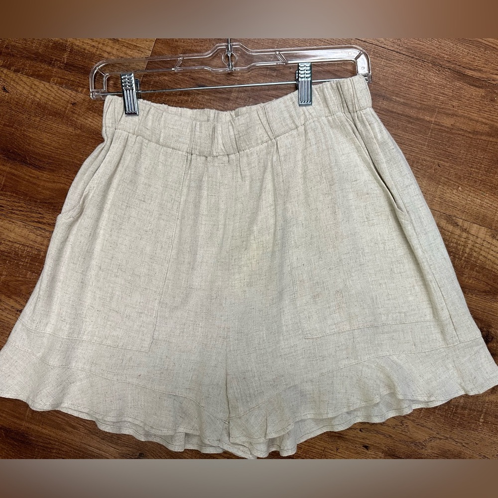Women’s linen cream shorts with hem ruffle